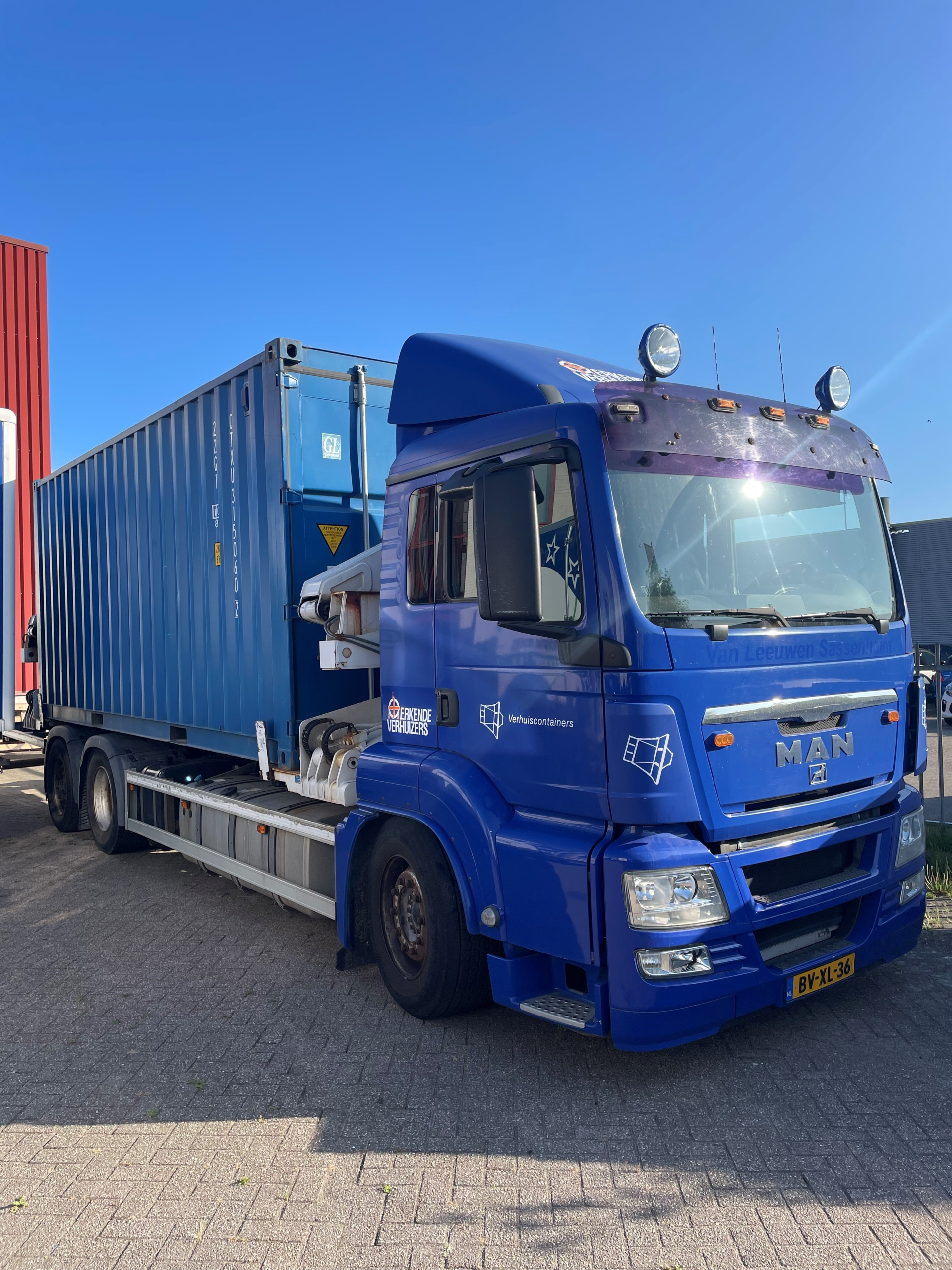 Afbeelding van een vrachtwagen side loader met container.