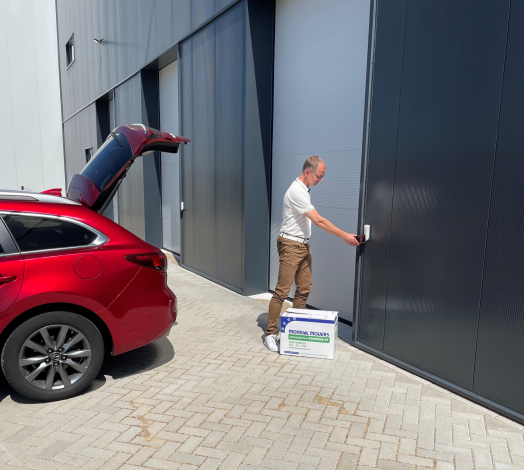 Afbeelding van directeur Lauwrens de Jong die via de selfstorage ingang de deur openmaakt.