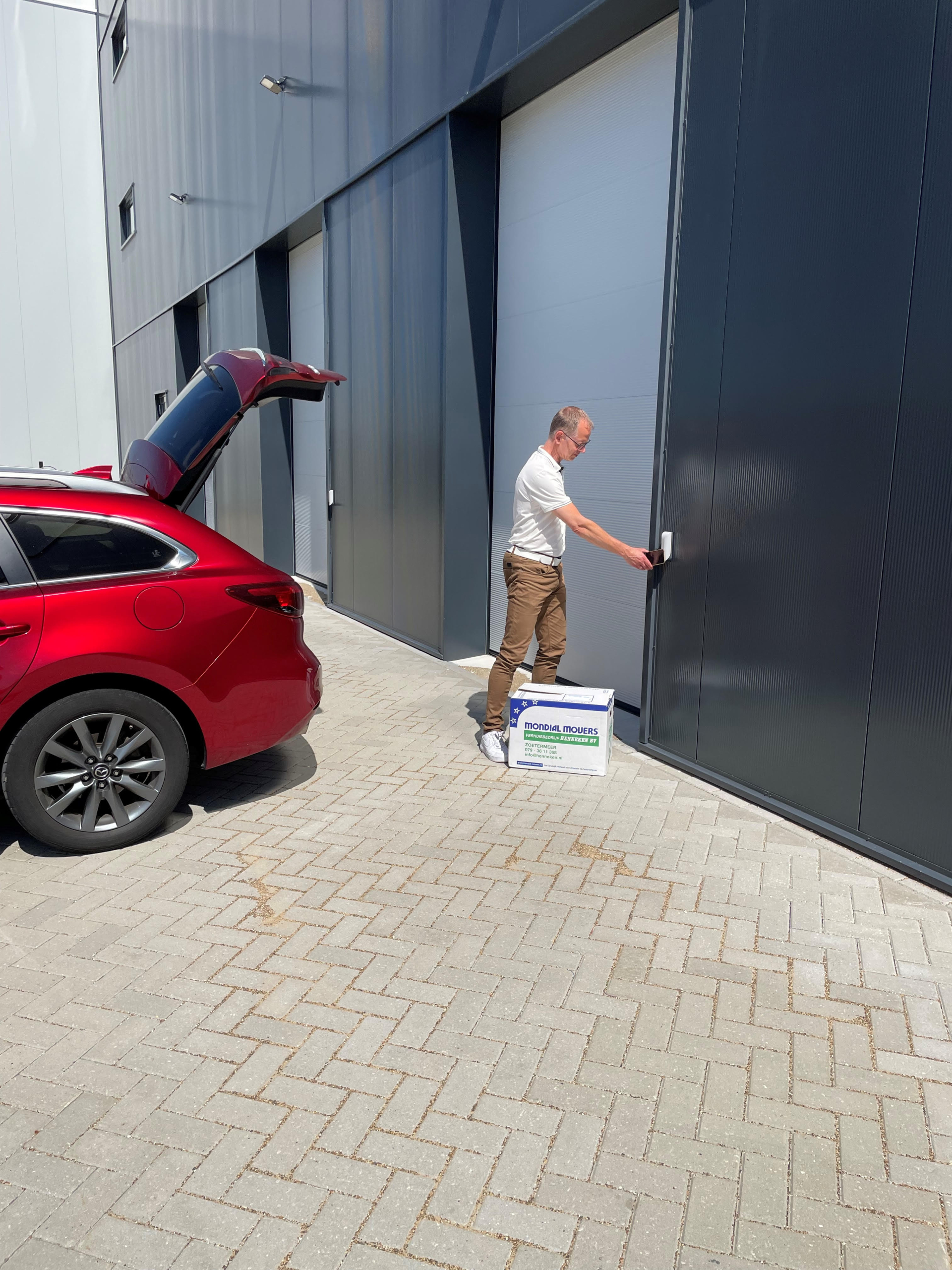 Afbeelding van directeur Lauwrens de Jong die via de selfstorage ingang de deur openmaakt.